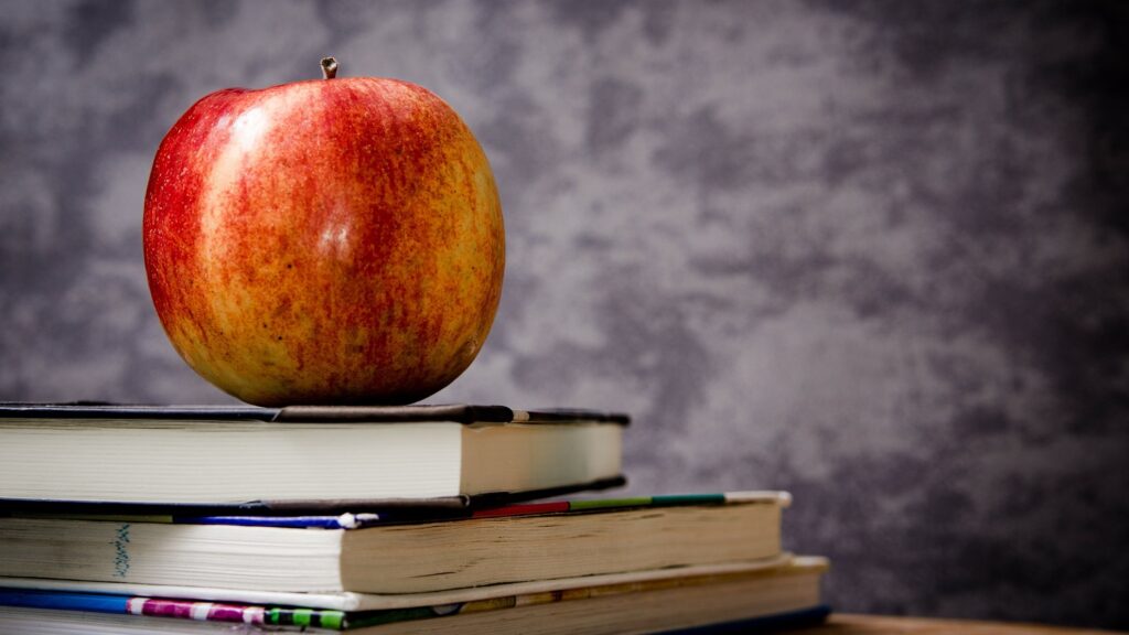 An apple on a stack of books.