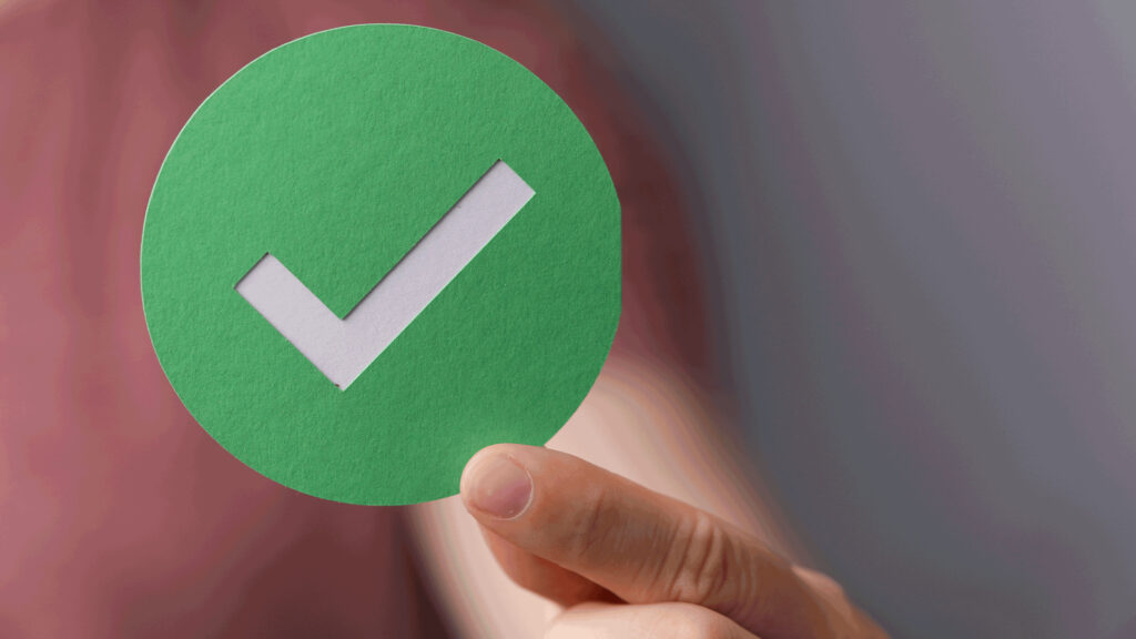A hand holing up a check mark to signify an online video platform that passes evaluation.