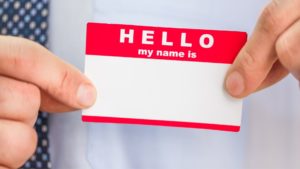 man holding "Hello my name is" name tag sticker demonstrates an element that could have a viewer's name on it in a personalized video