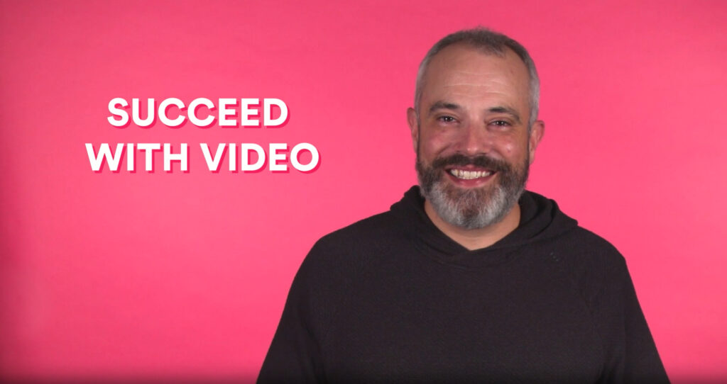 The presenter of Vidyard's video FAQ shown against a pink background.