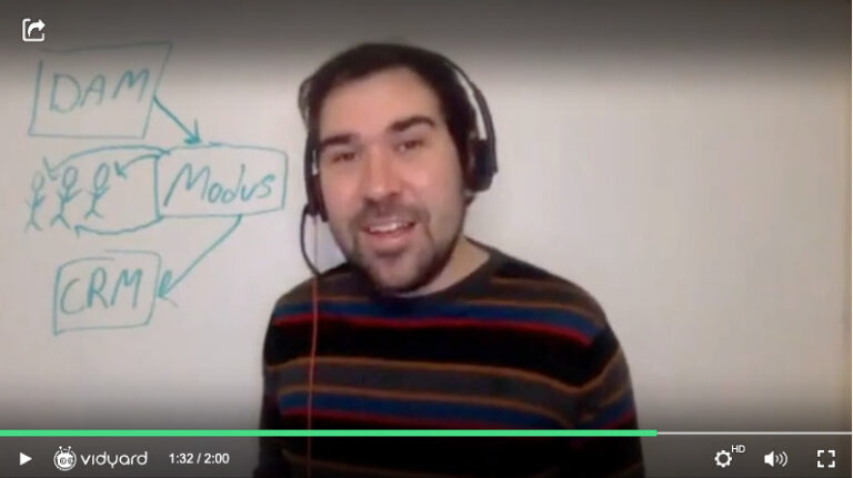 A screen of a Vidyard video featuring a male salesperson standing in front of a whiteboard answering a customer question