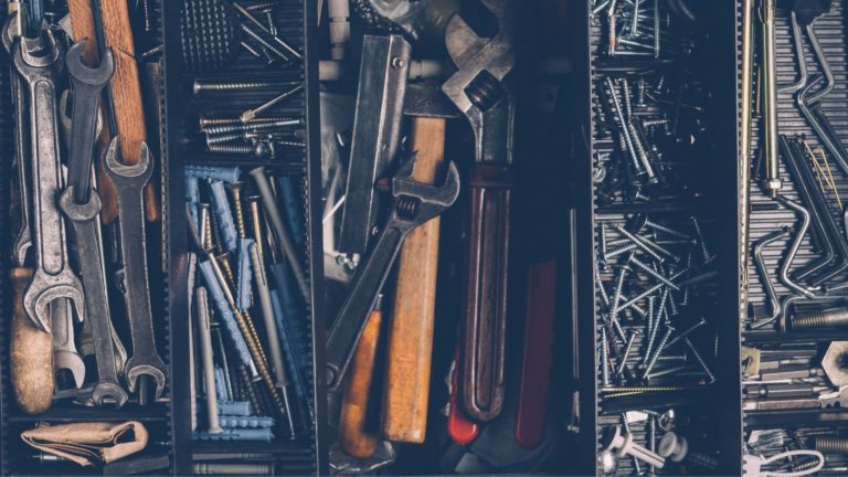 drawer full of tools, including wrenches and nails