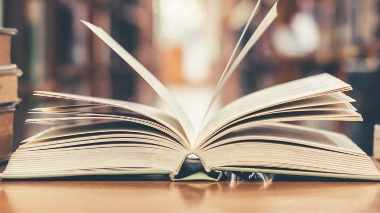 an open book sitting on a table in a library