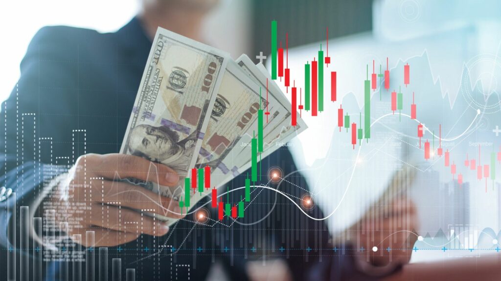 Businessman holding banknote and financial stock market graph on color city background, currency exchange, for finance and business concept.